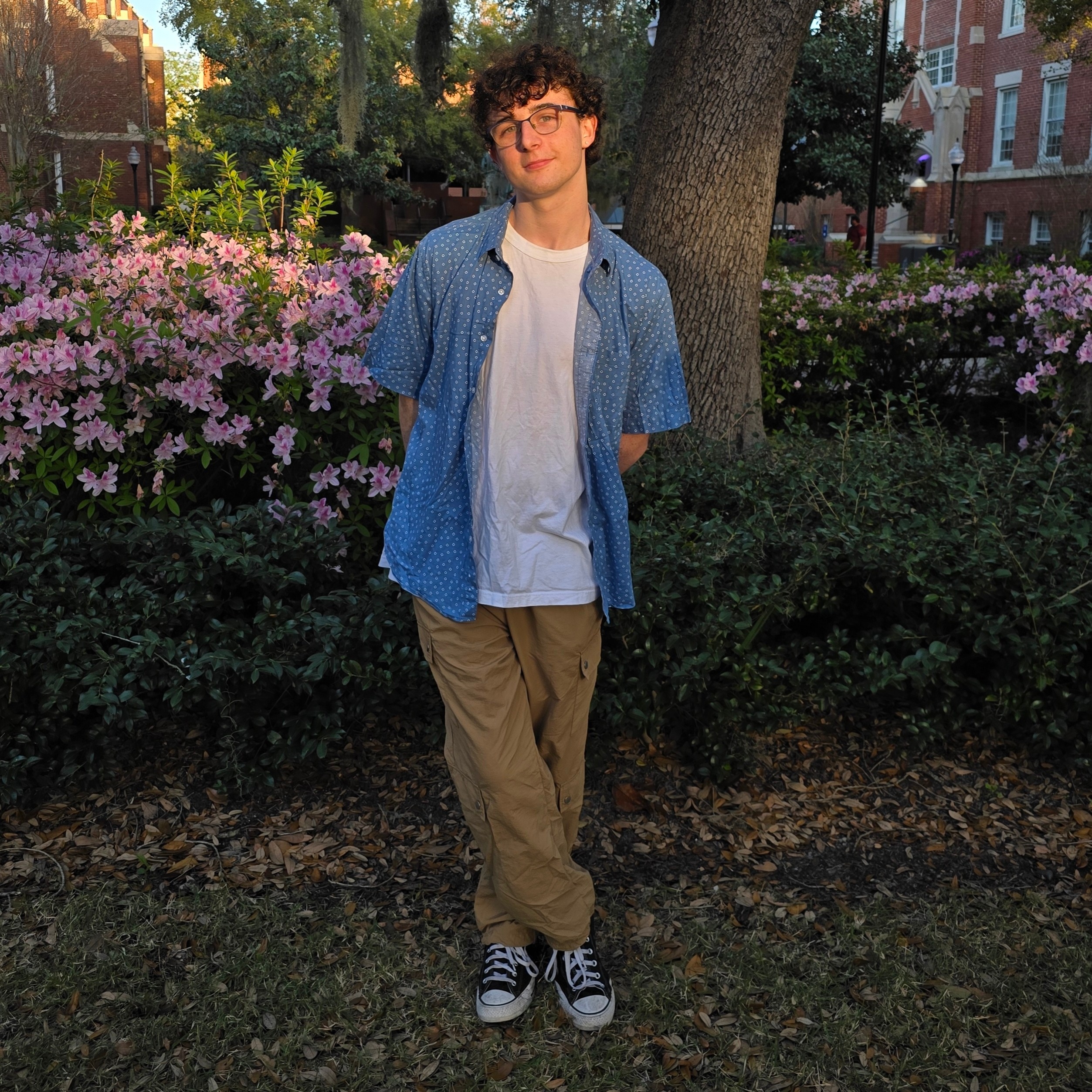 A picture of me at UF in front of flowering bushes